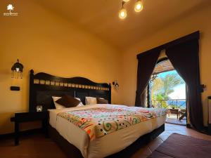 达哈布达哈卜天堂酒店的一间卧室设有一张大床,享有海景
