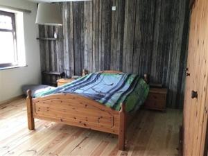 埃尔泽Vakantie & wellness Erezee的一间卧室配有一张木床,铺有木地板