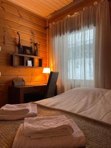 HollolaVilla Joutsen的一间卧室配有一张床、一张书桌和一个窗户。