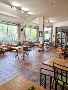 乌韦兹河畔莫朗Logis Hôtels Le Saint Marc的餐厅设有桌椅和窗户。