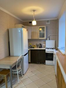 科克舍套Сдам квартиры посуточно的厨房配有白色冰箱、桌子和桌椅
