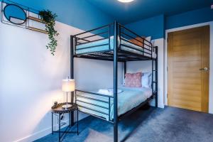 弗姆比Stunning 2 Bed Apt By Greenstay Serviced Accommodation - Perfect For SHORT & LONG STAYS - Couples, Families, Business Travellers & Contractors All Welcome - 7的一张黑色双层床,位于带边桌的房间里