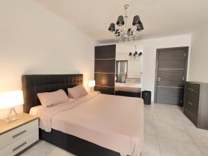 佩塔Large Central Apartment Near Valletta & Seafront的卧室配有一张白色大床和吊灯。