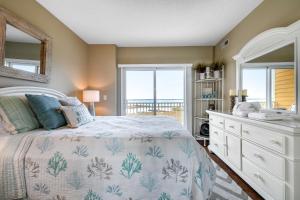 大洋城Playa Flamingo #302的一间卧室配有一张床、一个梳妆台和一扇窗户。