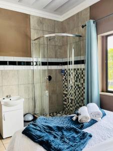 韦尔科姆Abecor Hotel的带淋浴的浴室以及带毛巾的床。