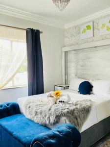 韦尔科姆Abecor Hotel的一间卧室配有一张带毯子和蓝色沙发的床
