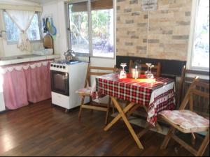 圣何塞德马约Cabaña Tía Sonia的厨房配有桌子和炉灶。 顶部烤箱