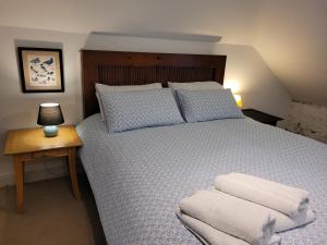Inch Cross RoadsBallyrider House Beautiful Triple Suite的一间卧室配有一张大床和木制床头板