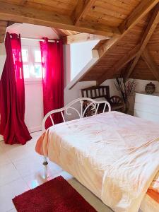 DucosVilla La Roserie的卧室配有白色的床和红色窗帘