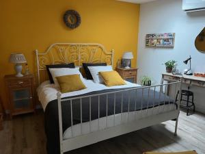 多德雷赫特De Drechtstee的一间卧室设有一张黄色墙壁的大床