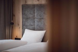 瓦尔道拉ROUDA luxury retreat am Kronplatz的卧室配有一张带白色枕头的床