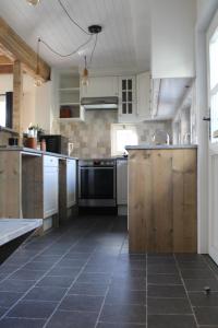 't Jongehof的一间设有白色橱柜和瓷砖地板的大厨房