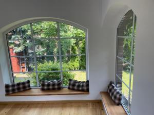 格但斯克旧城Willa BROWAR pokoje gościnne的客厅的拱形窗户,窗户边有靠垫