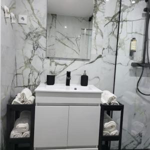 卡帕里卡海岸Nandos Apartement的浴室配有白色水槽和大理石墙壁。