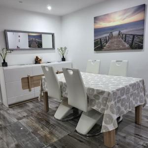 卡帕里卡海岸Nandos Apartement的一间带桌椅和绘画的用餐室