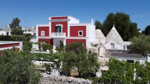 奇斯泰尼诺Masseria Trulli sull'Aia的一座红白色的树 ⁇ 山丘房子