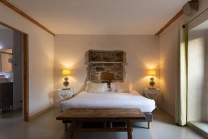 亚斯凯恩Hotel Residence Alaïa的一间卧室配有一张床、两盏灯和一张桌子。