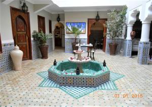 马拉喀什Riad Dar Teranga Hotel & Spa的一座房子,在房间中间有一个喷泉