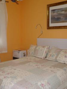 阿维莱斯Habitaciones en Aviles的卧室配有一张床,墙上挂着一幅画