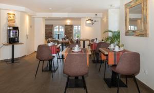 亚斯凯恩Hotel Residence Alaïa的一间在房间内配有桌椅的餐厅