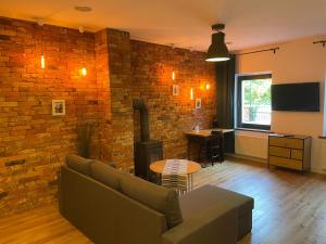 格但斯克旧城Willa BROWAR pokoje gościnne的带沙发和砖墙的客厅