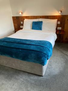沃里克Jersey Villa Guest House的一间卧室配有一张带蓝色床单的大床