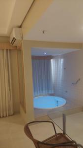 卡达斯诺瓦斯Apartamento luxo Hot Springs Caldas Novas tay的一间带浴缸及椅子的浴室