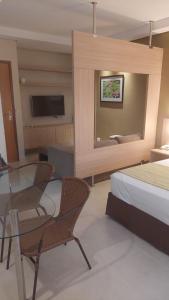 卡达斯诺瓦斯Apartamento luxo Hot Springs Caldas Novas tay的一间卧室配有一张床、一张玻璃桌和椅子