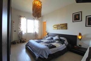 蒙蒂尼奥索Vista Mare的一间卧室配有一张大床和一个吊灯。