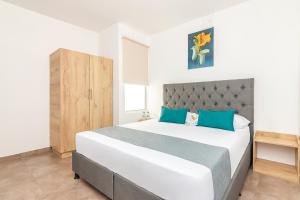 里奥阿查Casa Flor Hostel & Drinks的卧室配有带蓝色枕头的大型白色床