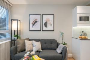 伦敦Westfield Apartment 2 Bedroom near Notting Hill的客厅配有沙发和墙上的照片