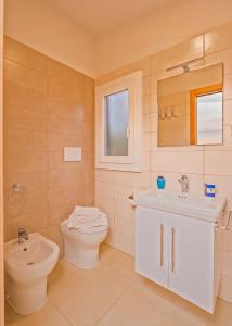 圣塔马里亚迪卡斯特Villaggio Leucosia的浴室配有白色卫生间和盥洗盆。
