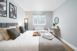 伦敦Westfield Apartment 2 Bedroom near Notting Hill的卧室配有一张大白色的床和书桌