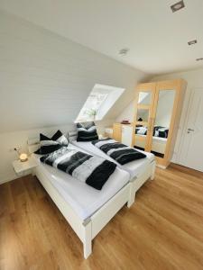 弗里德贝格Haus Dragl DZ EZ的卧室配有一张带黑色枕头的大型白色床。