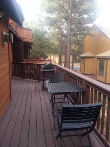 弗拉格斯塔夫Cozy Flagstaff Home in Cool Pines - Country Club的一个带两把椅子和一张桌子的甲板和烧烤架