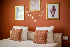 威廉斯塔德BOHO Bohemian Boutique Hotel的一间卧室拥有橙色的墙壁,床上配有白色枕头
