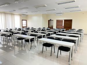 伊尼扬巴内Inhambane Hotel Escola的一间教室,里面配有白色的桌椅