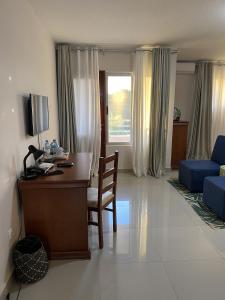 伊尼扬巴内Inhambane Hotel Escola的客厅配有书桌和蓝色沙发。