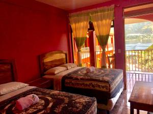 圣佩德罗拉拉古纳Hotel Adulam的一间卧室设有两张床和大窗户