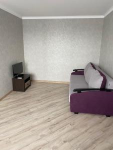 文尼察Apartament Vasilya Porika 48 Street Vinnitsya的一间卧室配有一张紫色的床和一台电视机