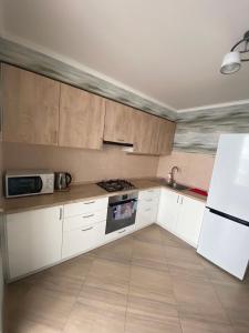 文尼察Apartament Vasilya Porika 48 Street Vinnitsya的厨房配有白色橱柜和炉灶烤箱。