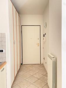 安杰利圣母Suite Angeli, a due passi da Assisi的走廊设有白色门,铺有瓷砖地板