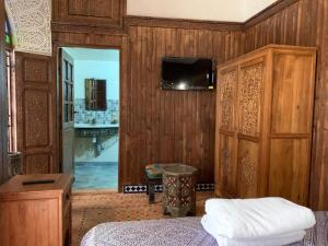 梅克内斯Riad Palais Marouane的卧室配有一张床,墙上配有电视。