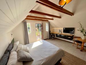 哈博罗内Cosy City Cottage的一间卧室配有一张床、一张沙发和一台电视。