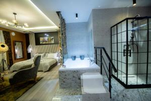 普里什蒂纳Hotel and Apartments Central City Prishtina的带浴缸的浴室和卧室