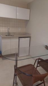 卡达斯诺瓦斯Apartamento luxo Hot Springs Caldas Novas tay的厨房配有玻璃桌和椅子