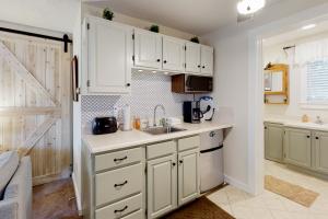 拉德洛Teddy's Getaway的厨房配有白色橱柜和水槽