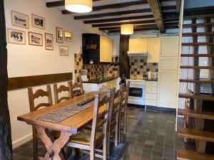 瑟穆瓦河畔夫雷斯La Petite Passerelle à Mouzaive的厨房配有木桌和椅子