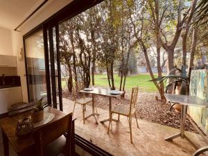 尼姆Charmant studio loft - Mas Bois Fontaine的客房设有桌椅和大窗户。