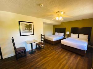 提华纳Hotel America的酒店客房设有两张床和一张桌子。